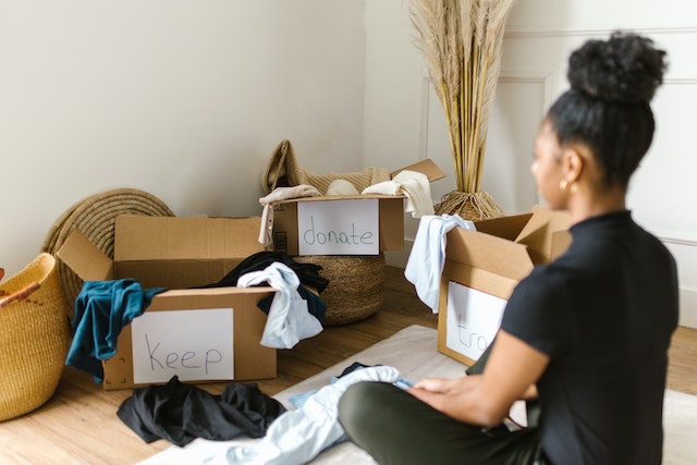 woman decluttering home with donation boxes